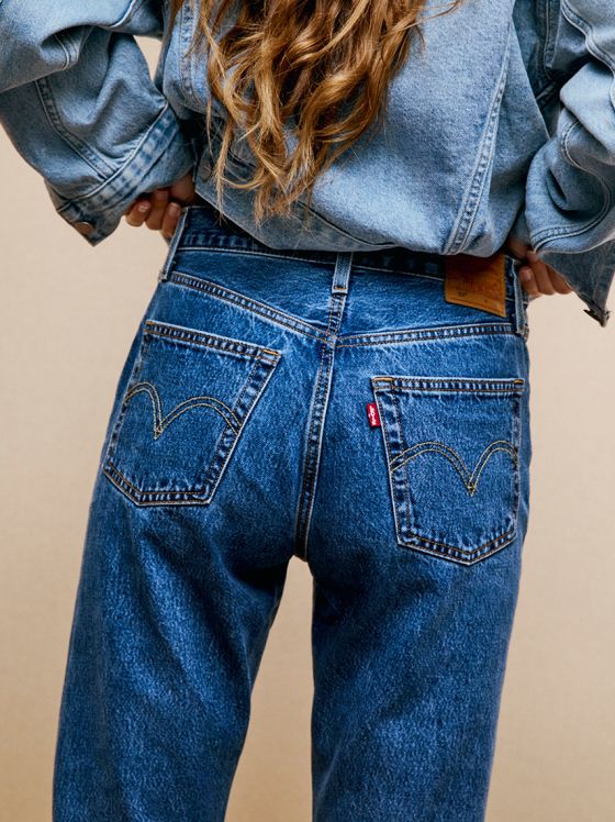 Nahaufnahme der Rückseite einer Frau in blauen Jeans und Jeansjacke.